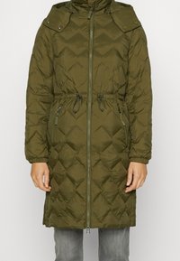 Manteau matelassé olive vert long avec fermeture éclair à l'avant, taille ajustable par cordon, poches zippées et rabats d'épaule à bouton-pression.