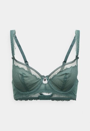 Στηθόδεσμος με μπανέλα φτιαγμένος από τιρκουάζ δαντέλα με λουλουδάτες λεπτομέρειες, ρυθμιζόμενες τιράντες και ένα μικρό ασημένιο διακριτικό στο μπροστινό κέντρο. Ημι-διάφατος σχεδιασμός.