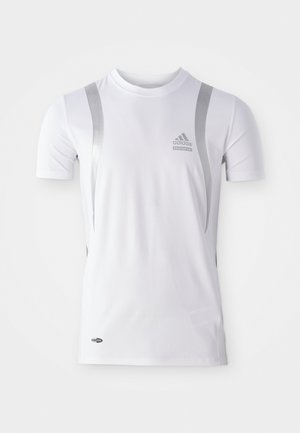 Camisa atlética de manga curta branca com detalhes prateados, apresentando um decote redondo e um logotipo da Adidas no peito. Feita de tecido que transfere a humidade.