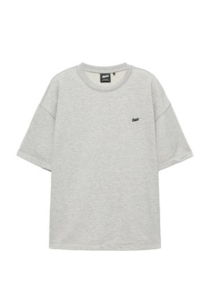 Lysegrå T-shirt med korte ærmer og rund hals med lille sort tekstlogo på venstre bryst og ribstrikket krave.