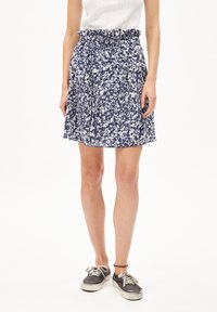 Blue and white floral patterned skirt with a gathered waistband, above-knee length, paired with gray sneakers. Lightweight fabric texture.