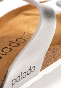 Sandal in argento con una fascia testurizzata, suola in sughero e soletta in gomma con bordo bianco. Marcato con "palado" sulla soletta.
