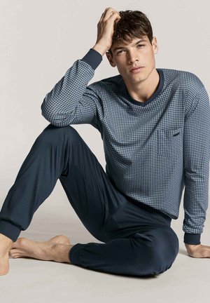 Ensemble de pyjama pour hommes comprenant un haut à manches longues bleu à motifs avec un col rond et une poche, associé à un pantalon ajusté bleu foncé.