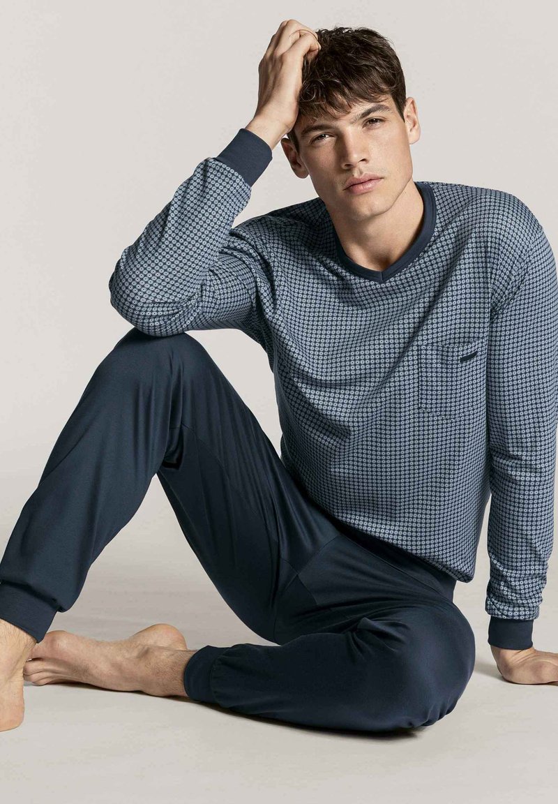 Heren pyjama set met een blauwe patroondessin long-sleeve top met een ronde hals en een zak, gecombineerd met donkerblauwe tapse broek.