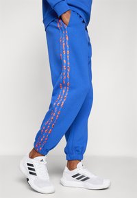 adidas Sportswear ESSENTIALS 3 STRIPES ANIMAL PRINT 7/8 PANT - Tracksuit bottoms - semi lucid blue/multicolor