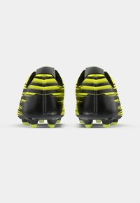 Μαύρα και νέον κίτρινα ποδοσφαιρικά παπούτσια με υφή στην επιφάνεια, λεπτό σχέδιο με λωρίδες και εμφανείς τάπες για καλύτερη πρόσφυση.