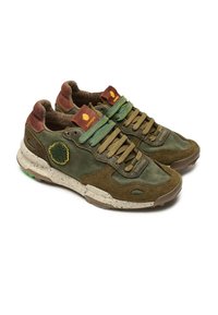 Sneakers verdi realizzati in suede e pelle con una suola puntinata, lacci verdi e un emblema decorativo sul lato.