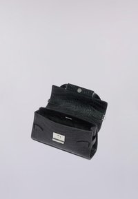 Svart läderhandväska med krokodilåteliknande struktur, med ett silverfärgat spänne och två yttre sidoremmar. Inuti är väskan öppen och fodrad.