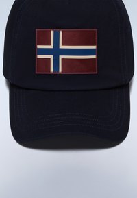 Marinkeps med ett rektangulärt märke med den röda och blå norska flaggan. Kepan har en strukurerad form och synliga sömnadsdetaljer.