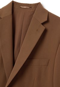 Blazer marrone con rever a scollo a V, tasca sul petto singola e texture sottile. Realizzato in tessuto lavorato con una finitura liscia.