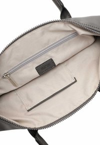 Intérieur de sac à main gris avec un revêtement en tissu lisse. Comprend une poche zippée et une poche à glissière, toutes deux dans une couleur beige plus claire.