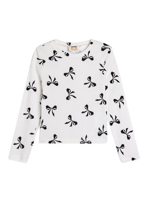 Chemise blanche en coton à manches longues avec un motif de nœuds noirs. Texture côtelée, encolure ronde et coupe droite.