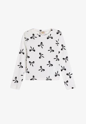 Camicia bianca in cotone a maniche lunghe con motivo di fiocchi neri. Tessuto a costine, collo rotondo e taglio dritto.