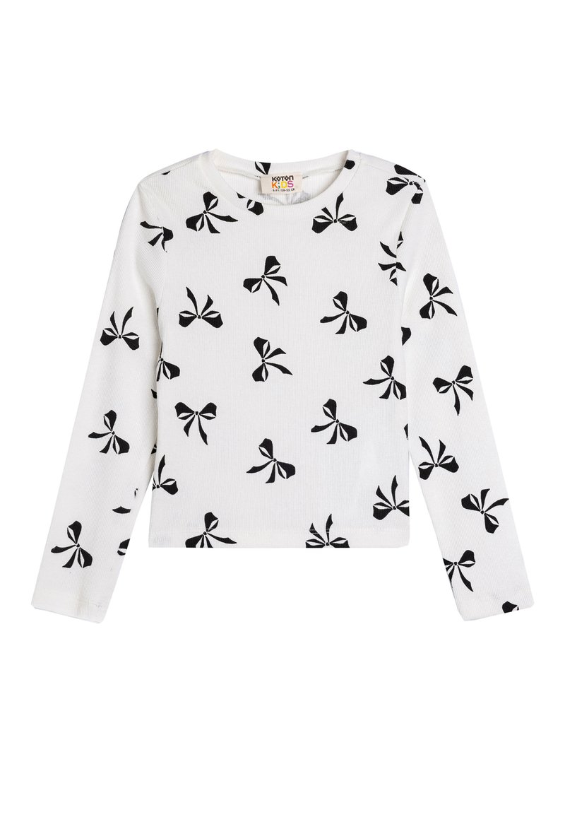 Camicia bianca in cotone a maniche lunghe con motivo di fiocchi neri. Tessuto a costine, collo rotondo e taglio dritto.