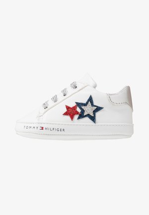 Baskets blanches basses avec lacets argentés, patchs étoiles pailletées rouges et bleues, et logo "Tommy Hilfiger" sur la semelle.