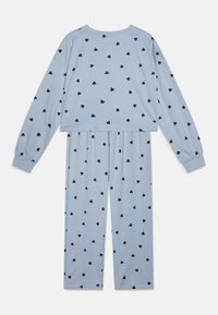 Lyseblå pysjamassett med lange ermer og bukser, med svarte hjerte mønstre. Myk stoff med avslappet passform og elastisk midjebånd.