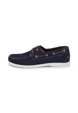 Scarpa da barca in pelle blu navy con cuciture bianche, lacci in pelle marrone e suola in gomma bianca, vista laterale.