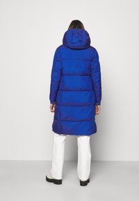 Blue puffer coat with a hood, featuring a quilted design and elastic cuffs. The coat is knee-length with a glossy finish and solid color.
