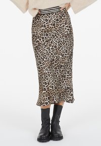 Leopard print midi skirt with a smooth texture and a black and white striped waistband. The design features a flared hem that adds movement.