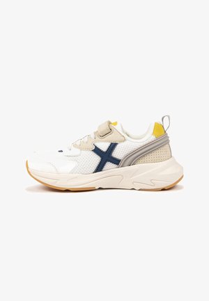 Witte mesh sneaker met grijze accenten, marineblauw kruisontwerp, gele hieltab en een rubberen zool met structuur. Lichtgewicht constructie.
