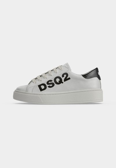Baskets basses blanches avec semelle épaisse, languette noire au talon et inscription noire audacieuse "DSQ2" sur le côté.