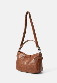 Brown leather shoulder bag with adjustable strap, flat base, magnetic closure, and double handles. Subtle texture and minimalistic design.