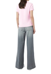 Camiseta rosa de manga corta combinada con pantalones de denim gris de pierna ancha. Ambas prendas tienen una textura suave sin patrones ni acentos visibles.