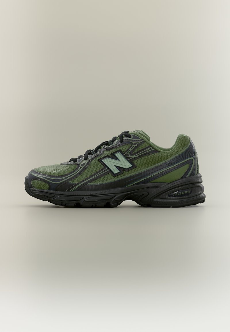 Πράσινο και μαύρο αθλητικό παπούτσι New Balance με επάνω μέρος από δίχτυ, μαξιλαρωμένη σόλα και λογότυπο "N" στο πλευρό, εμφανίζεται σε πλευρική προβολή σε ουδέτερο φόντο.