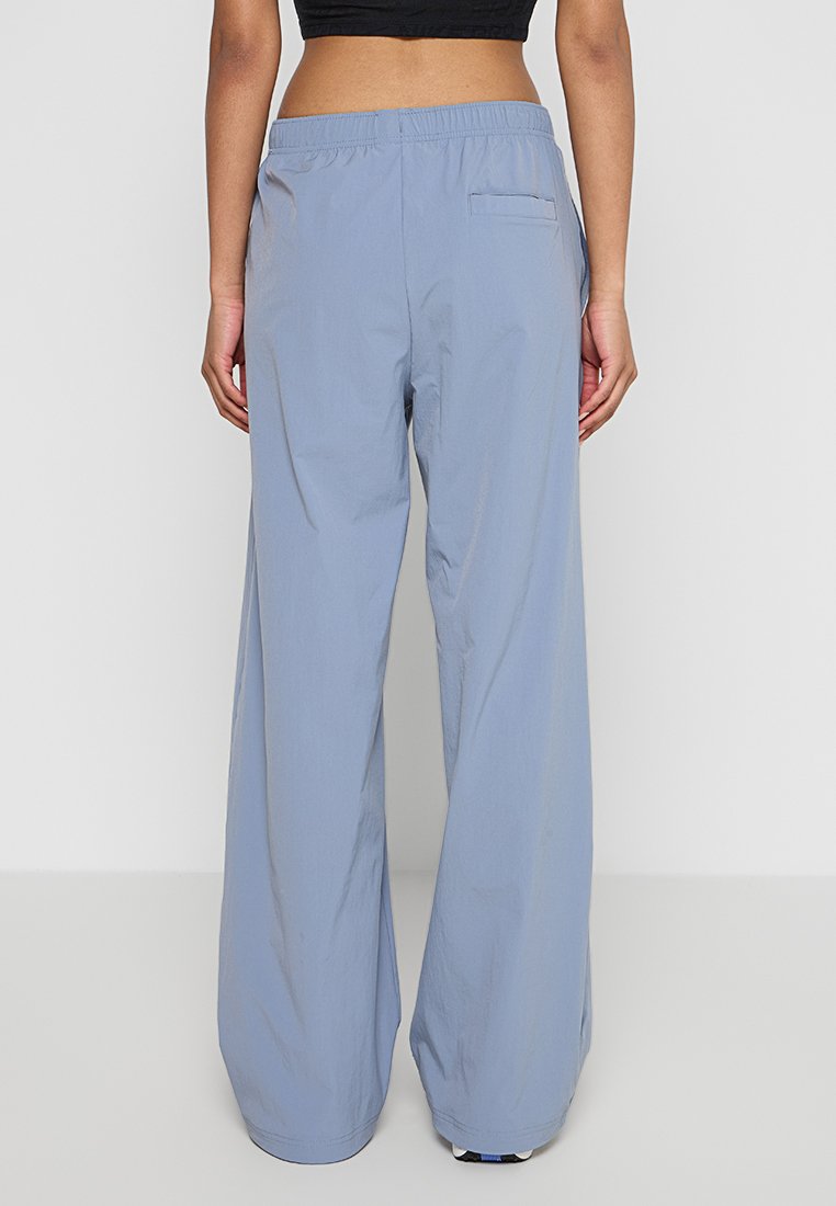 Pantalones de pierna ancha en azul claro, hechos de una tela suave y ligera. Cuenta con una cinturilla elástica y un bolsillo trasero.