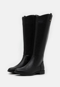 Black knee-high boots made of smooth leather with a side zipper, almond-shaped toe, and low block heel. Simple design without embellishments.