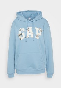 Svetlomodrá mikina s klokaním vreckom, s kvetinovým bielym logom "GAP" a farebnými akcentami. Mäkkučký materiál a nastaviteľná šnúrka na kapucni.