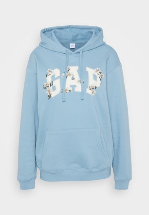 Ljusblå hoodie med känguruficka, med en blomsterdesign av "GAP"-logotypen i vitt och färgglada accenter. Mjukt tyg och justerbar dragsnodd vid huvan.