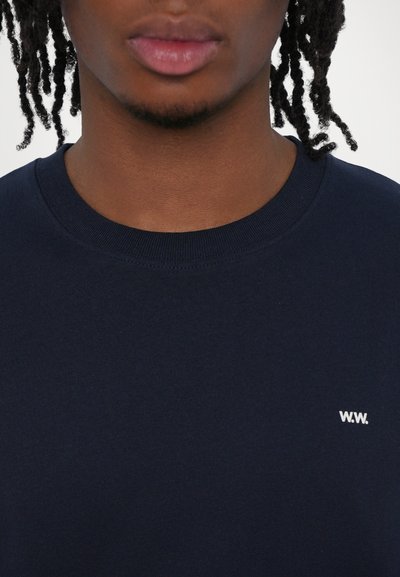 Marinblå sweatshirt med rund halsudskæring, lavet af bomuldsblanding, med et lille hvidt "W.W." logo på brystet.