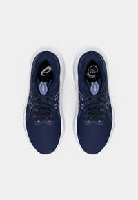 Zapatillas deportivas en color marino con parte superior de tela texturizada, suela blanca contrastante y cordones azul oscuro. Presenta un logo y elementos de diseño transpirables.