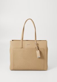 Beige tote bag made of textured synthetic material with two top handles, a front pocket, and a detachable tag. Zipper closure at the top.