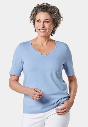 Lichtblauw T-shirt met korte mouwen en V-hals, versierd met kleine decoratieve studs bij de halslijn, gemaakt van zacht materiaal.