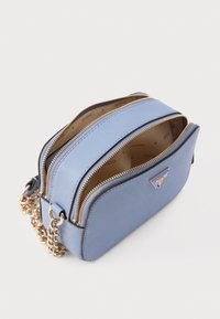Τσάντα χιαστί από γαλάζιο συνθετικό δέρμα με χρυσούς μεταλλικούς τόνους, δύο θήκες με φερμουάρ και αλυσίδα λουράκι. Η εσωτερική επένδυση διαθέτει εκτύπωση με λογότυπο.