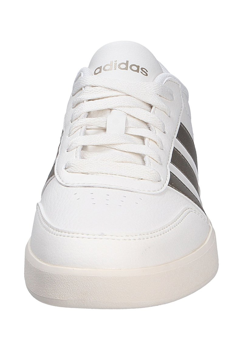Baskets Adidas blanches avec une tige en cuir lisse, présentant trois rayures gris foncé, une forme arrondie au niveau des orteils et une semelle plate en caoutchouc crème.