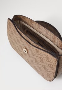 Ruskea kuvioitu käsilaukku, jossa on teksturoitu, kudottu pinta ja kultainen painonappi. Sisältää sisäpuolelta vetoketjullisen taskun ja beigevuorauksen.