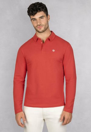 Langarm poloshirt in een effen rode kleur, gemaakt van zachte stof. Heeft een kraag, een knoopsluiting met drie knopen en een klein wit logo.
