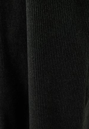 Tissu noir à rayures avec une surface texturée et des lignes verticales. Le matériau semble doux et chaud, adapté pour des vêtements ou des accessoires.