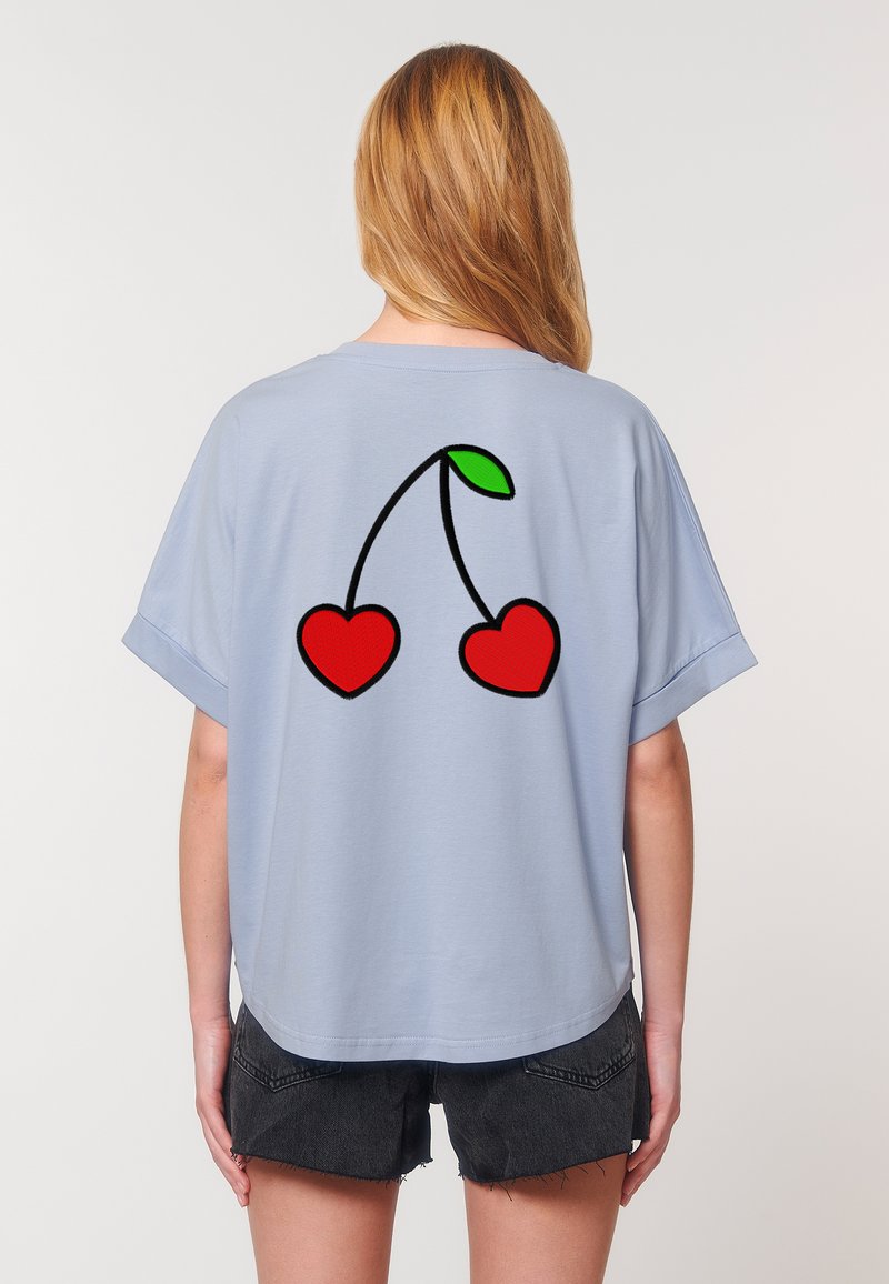 Lichtblauw shirt met korte mouwen en een ronde hals, met op de achterkant een zwarte omlijning van twee rode harten en een groen blad.