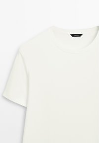 Effen witte katoenen T-shirt met korte mouwen, een ronde hals en een klein zwart label aan de binnenkant van de kraag.