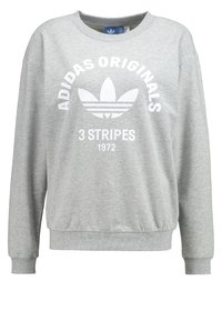 Ljust grå Adidas Originals sweatshirt med vit trefoil-logotyp, "3 Stripes" och "1972" text på framsidan, ribbade ärmslut och midja.