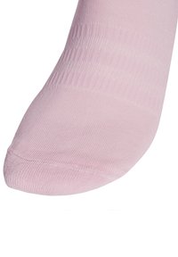 Svetloružová ponožka po členky vyrobená z hladkého, elastického materiálu. Má zosilnenú špičku a rebrovaný lem pre bezpečné uchytenie bez sklzu.