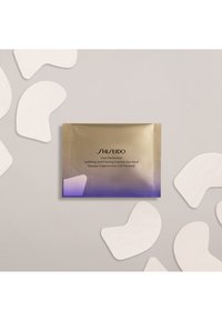 Paquete dorado y púrpura etiquetado como "Shiseido Vital Perfection Uplifting Eye Mask" con mascarillas oculares blancas y curvas alrededor, sobre un fondo claro.