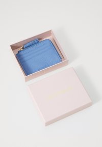 Portafoglio in pelle blu con finitura texturizzata, multiple fessure per carte e un comparto con zip, presentato in una scatola rosa chiaro con testo dorato.