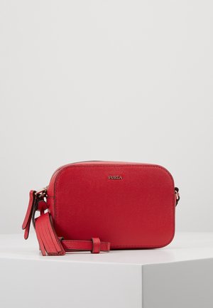 Rode Furla leren crossbodytas met gouden logo, verstelbare riem en kwastdetail, geplaatst op een wit voetstuk tegen een lichtgrijze achtergrond.