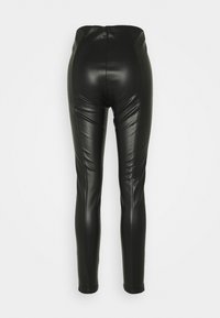 Högmidjade svarta leggings i konstläder med en åtsittande, glansig textur och synliga sömmar på baksidan och benen.