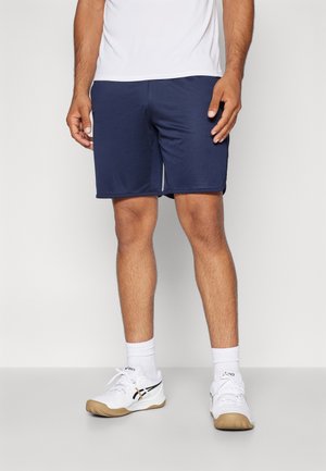 Shorts de sport bleu marine en matière légère avec une ceinture élastique, associés à des baskets blanches avec des accents noirs et marron clair.